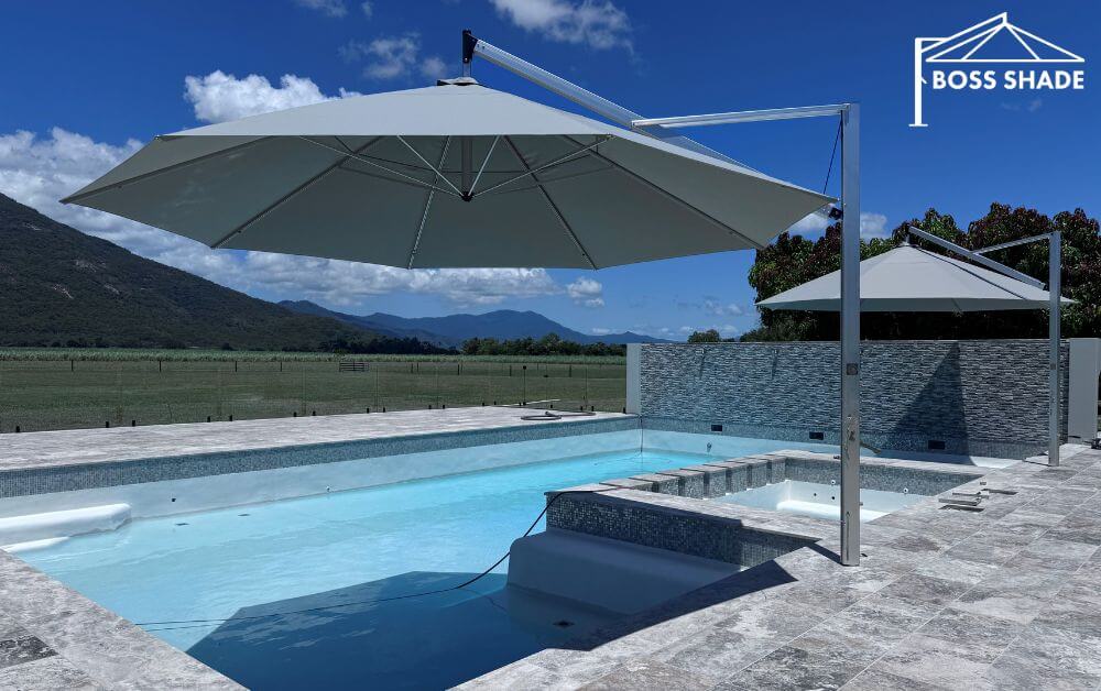 Large cantilever pool umbrella covering outdoor lounge and pool space